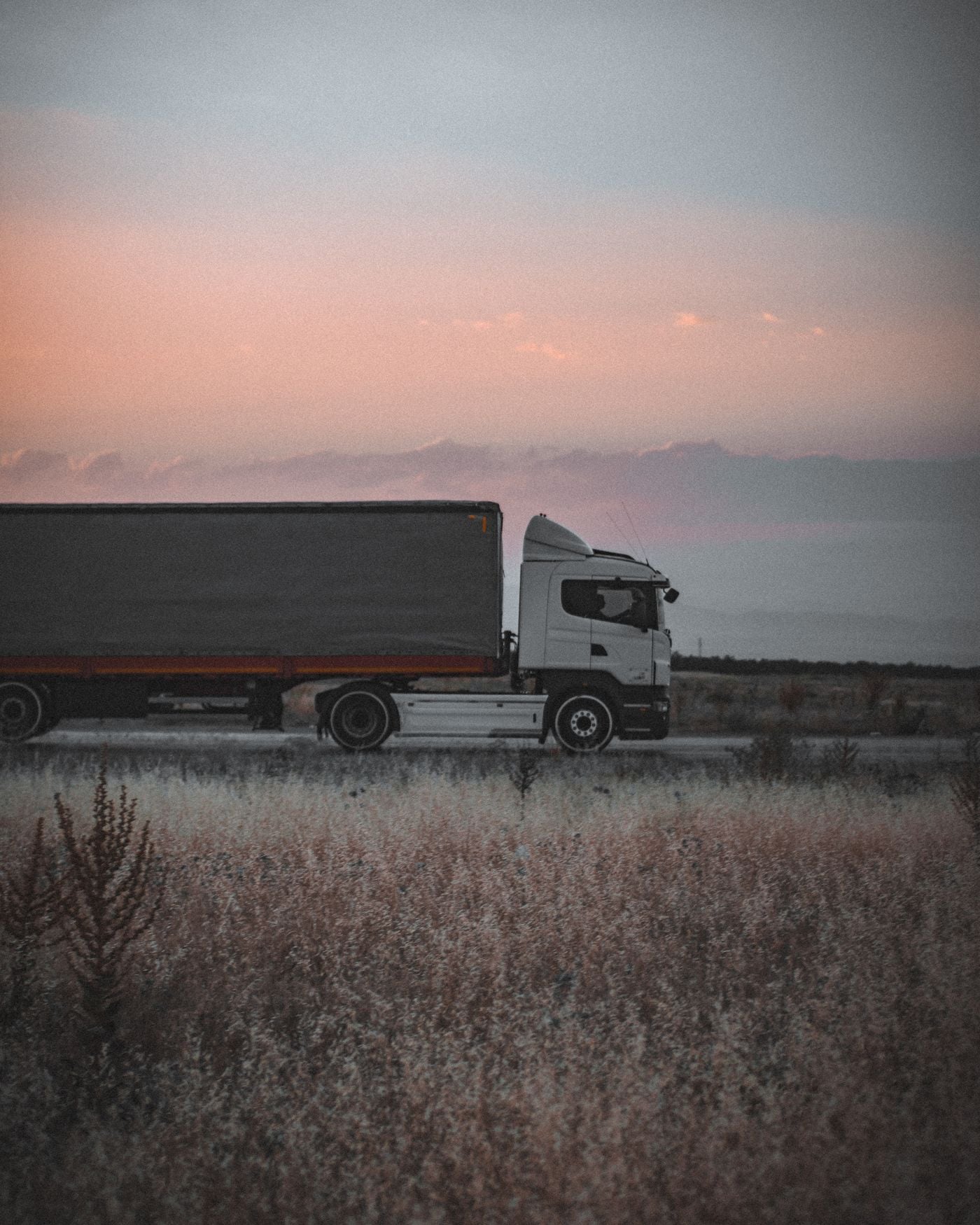 Freight truck travelling along a highway at sunset